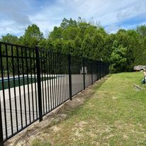 Black metal fence along a yard