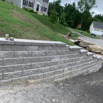Block retaining wall along a sloped yard