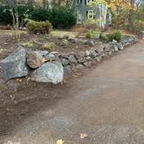 Boulder retaining wall beside a driveway