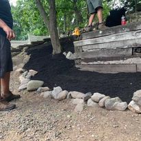 Crew setting stone edging on a raised bed