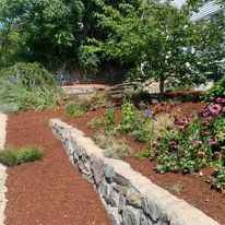 Fieldstone wall with a mulched planting bed