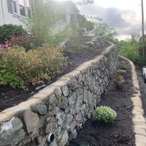 Fieldstone wall with mulch and plants