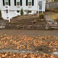 Stone wall and steps across a front yard