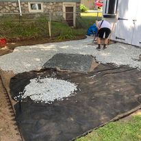 Spreading gravel over landscape fabric