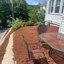 Red mulch bed around a patio table